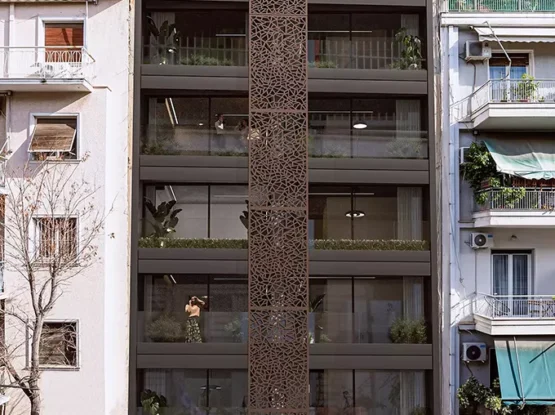 Modern residential building at Acharnon 60, Athens, featuring a distinctive brown perforated vertical screen and contemporary facade design, visualized by VARC Studio.