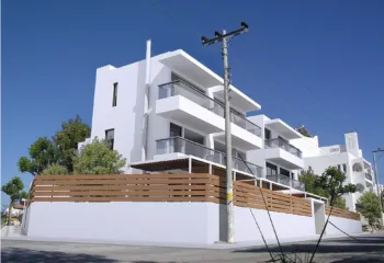 Exterior view of a minimalist residential building at the corner of Lerou and Lypson streets in Panorama Voula, designed by ISV Architects and built by Skotidas.