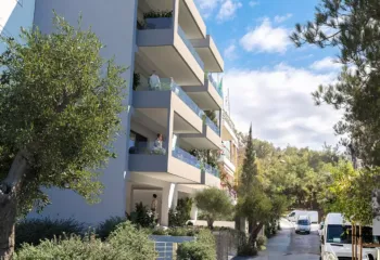 Exterior 3D architectural rendering showing a side street view of a modern minimalist apartment building in Galatsi, integrated into a green neighborhood next to Veikou Hill.