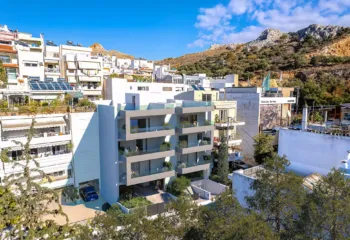 Modern architectural design of a luxury apartment building in Galatsi, featuring clean lines, glass balcony railings, and vertical green elements.