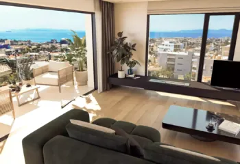 Elevated living with a view that never ends. Project: Ikarou 7 | Developer: Thekla Constructions. High-angle interior view of a luxury penthouse in Alimos showing the living area spacious balcony and panoramic sea view of the Saronic Gulf by Thekla Constructions