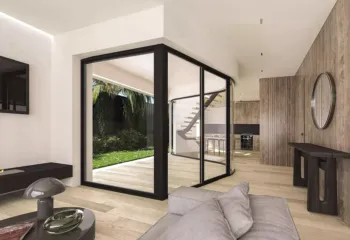 Fluid design and natural light. Project: Ikarou 7 | Developer: Thekla Constructions. Interior visualization of a luxury maisonette in Alimos featuring a minimalist staircase curved floor-to-ceiling glass walls and a view of a private garden by Thekla Constructions