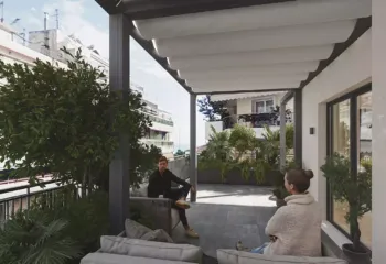 Exterior 3D rendering of a luxury penthouse balcony in Pasalimani Piraeus, showcasing a modern aluminum pergola canopy, comfortable outdoor sofas, and lush green planters.