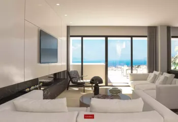 Panoramic sea views from the heart of the Amerikis 2 penthouse. Modern 3D interior visualization of a penthouse living room in Ano Glyfada, featuring a minimalist design, designer lighting, and large glass doors with a panoramic sea view.
