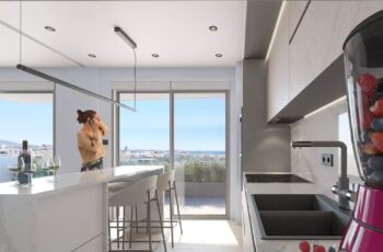A state-of-the-art kitchen at Palaio Faliro Loft featuring a premium marble breakfast bar, integrated appliances, and a breathtaking view of the Saronic Gulf. Luxury modern kitchen with marble island and sea view in Palaio Faliro Loft