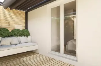 Modern balcony with wooden deck floor, built-in sofa and pergola in Agios Dimitrios