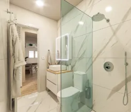 Luxury modern bathroom with marble tiles and walk-in glass shower in Agios Dimitrios