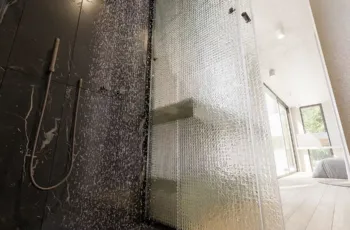 Interior 3D architectural rendering from inside a luxury walk-in shower, featuring black marble walls, a fluted glass screen, a rain shower head, and a view of the vanity unit.