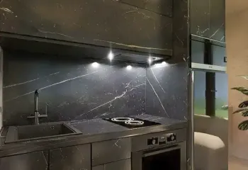 Interior 3D architectural rendering showcasing a close-up of a modern industrial kitchen with black marble backsplash, built-in cooktop, and under-cabinet LED lighting.