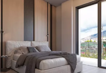 Contemporary bedroom design with premium finishes for the Glyfada residence. Modern bedroom with elegant wood paneling and mountain view, featuring professional 3D Rendering Services in Athens by VARC Studio.